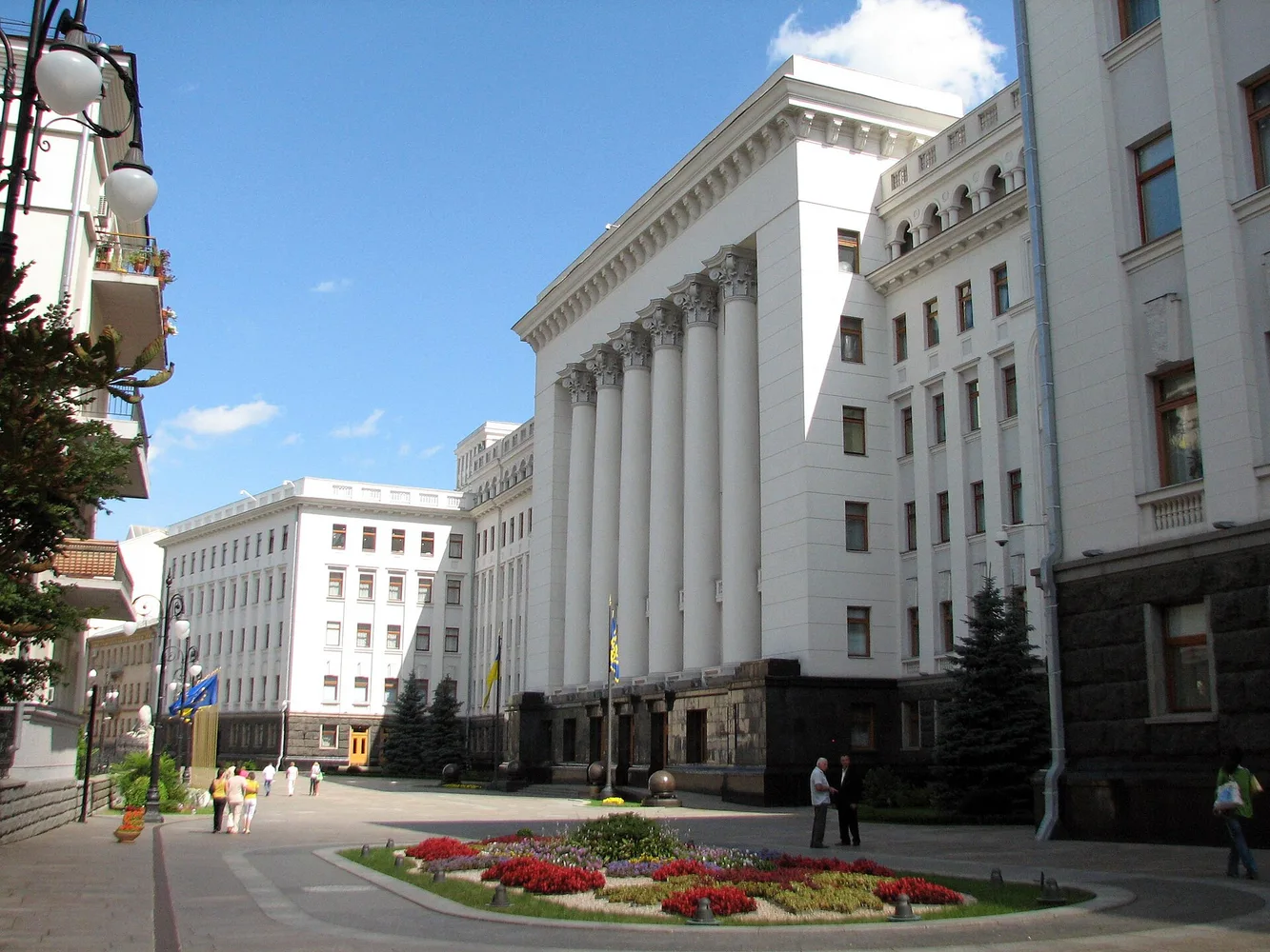 Будівля Офісу Президента України на вулиці Банкова, фасад з колонами, клумба та прапори біля входу